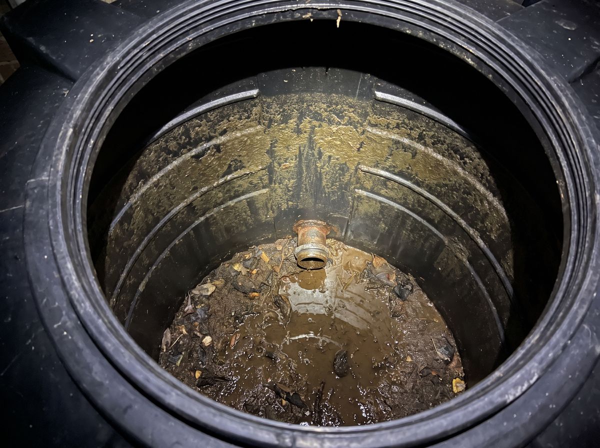 Silt, leaves and algae on the floor of a drained JoJo tank before cleaning in Randburg