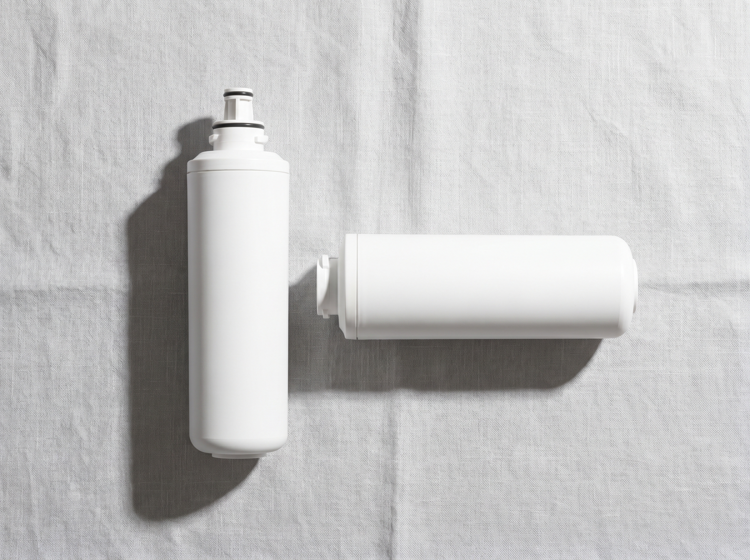 Two LG fridge water filter cartridges on a white surface showing the twist-in LT700P and push-button LT1000P formats side by side